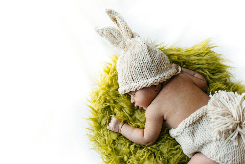 うさぎの帽子をかぶったうつ伏せ寝の赤ちゃん