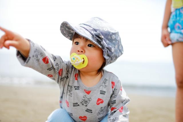 おしゃぶりを吸っている帽子を被った女の子