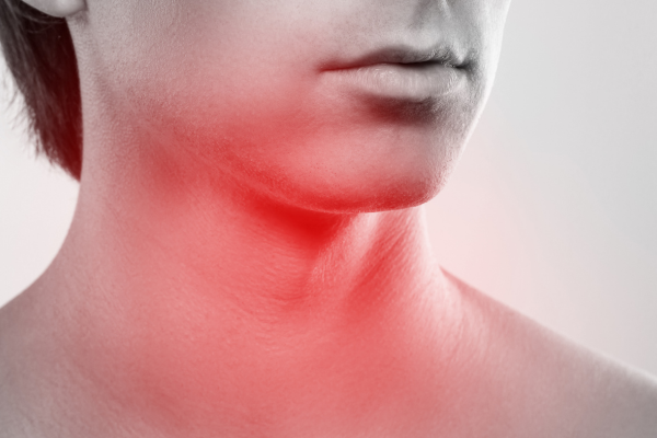 喉元が赤く染まっている男性の口元の白黒画像