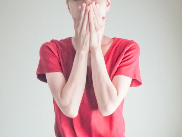 両手で口を隠している女性