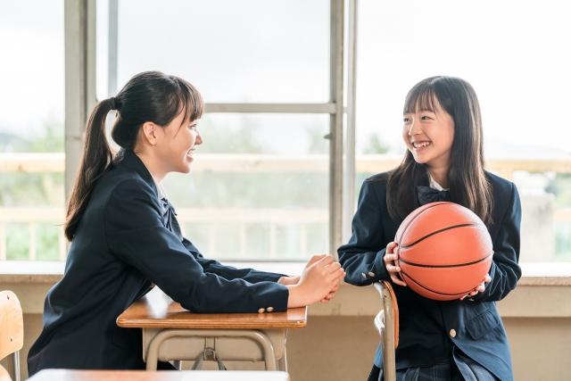 バスケットボールを持って教室で談笑している女学生