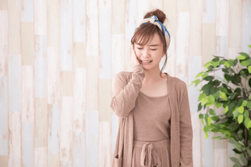 頬を押さえる女性