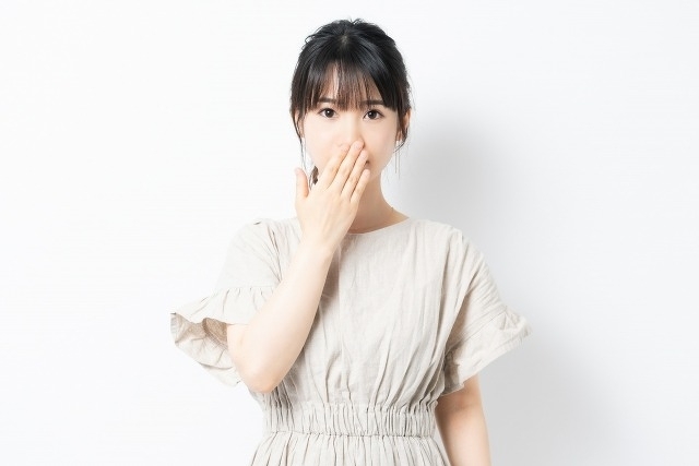 口元を鏡で見る女性