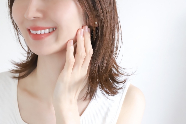 顎に手を添えて笑っている女性の口元