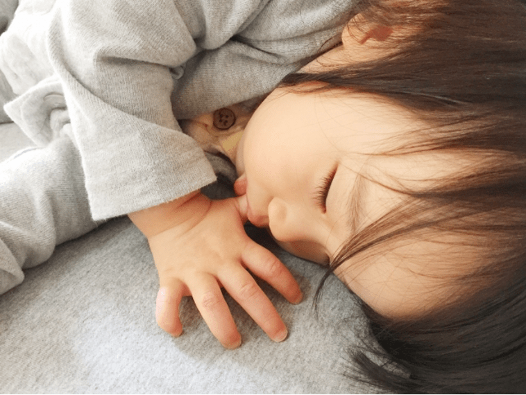 指しゃぶりをしながら寝ている子供
