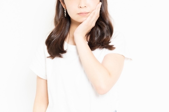 頬を押さえる女性