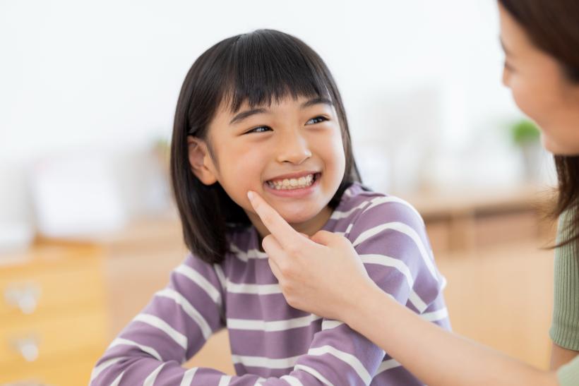 母親と歯並びの話をする笑顔の女の子