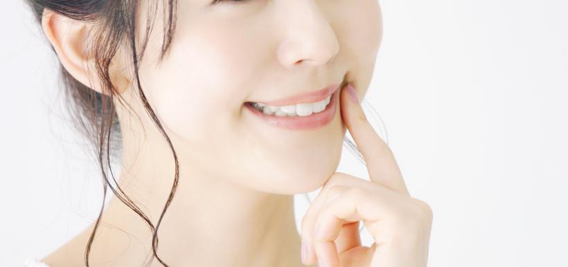 笑顔で口元をおさえる女性