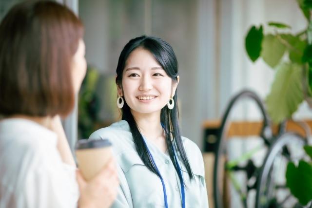 友人とカフェで笑う女性