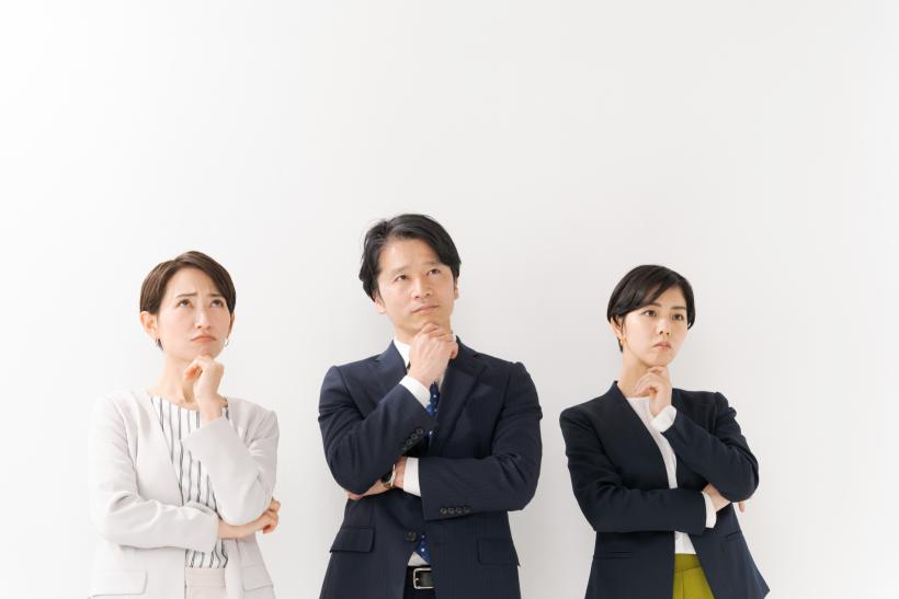 腕を組んで考える３人の大人