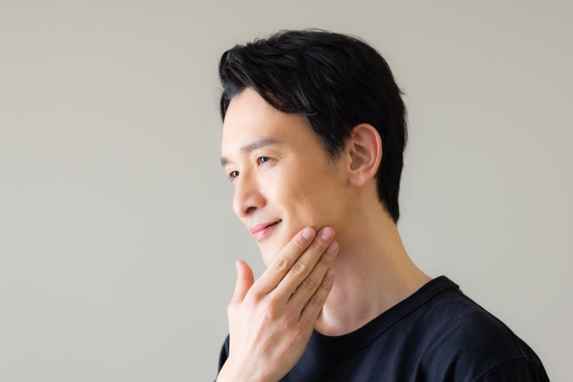 顎に手を当てる男性